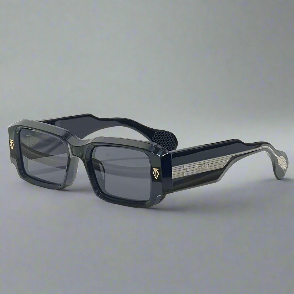 Black sunglasses with gold accents on a wooden surface