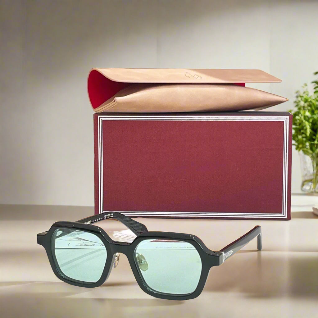 Sunglasses with a red and gold box on a light background