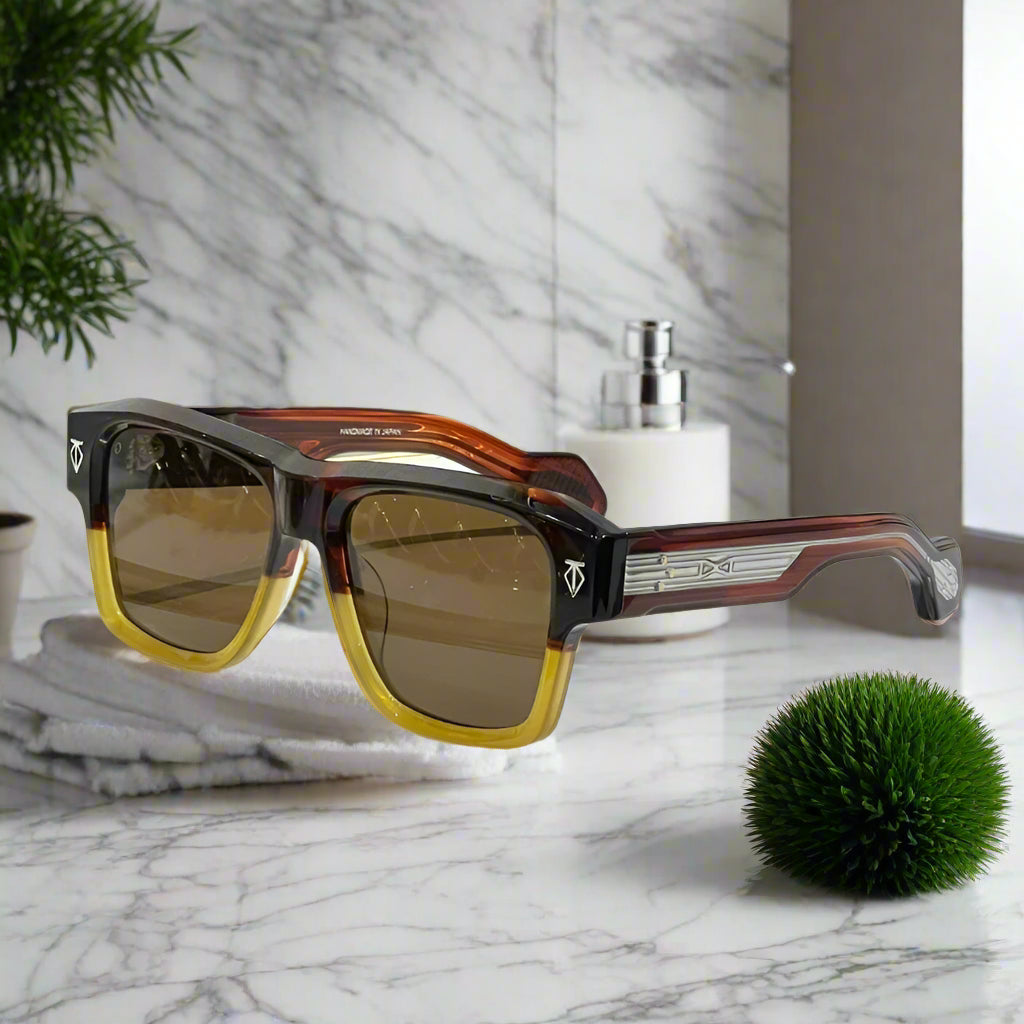 Sunglasses with brown lenses and tortoiseshell frame on a white surface with a black case in the background.