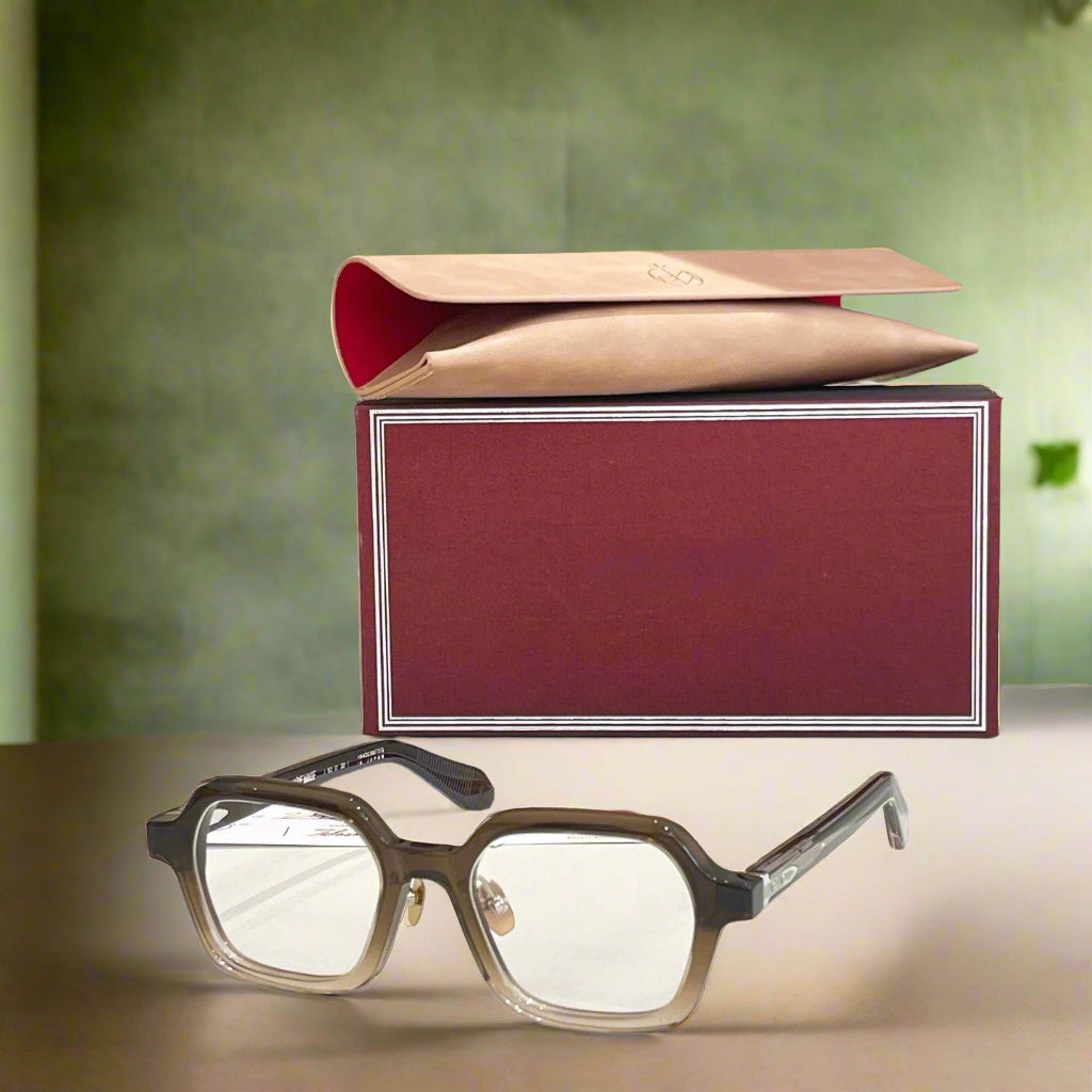 Eyeglasses with a red and gold box on a light surface