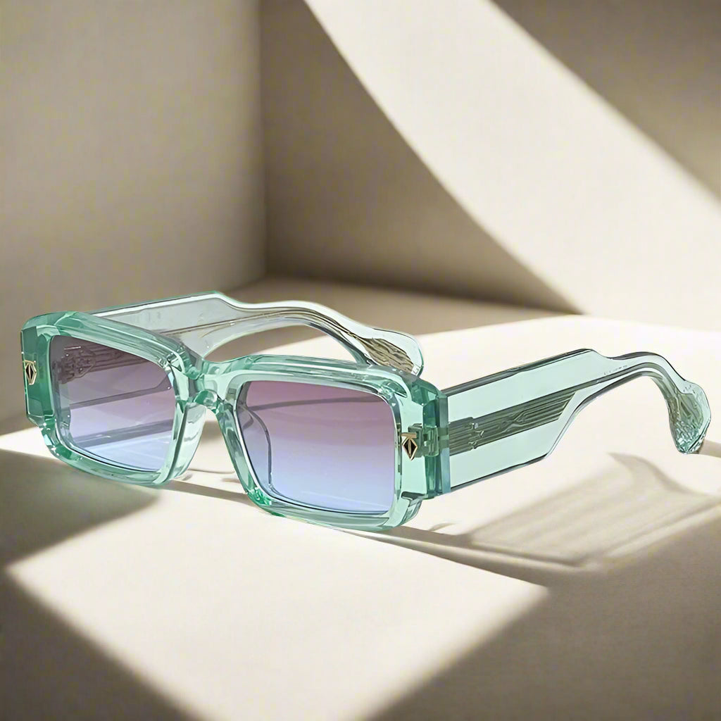 Green sunglasses with a transparent frame on a white surface