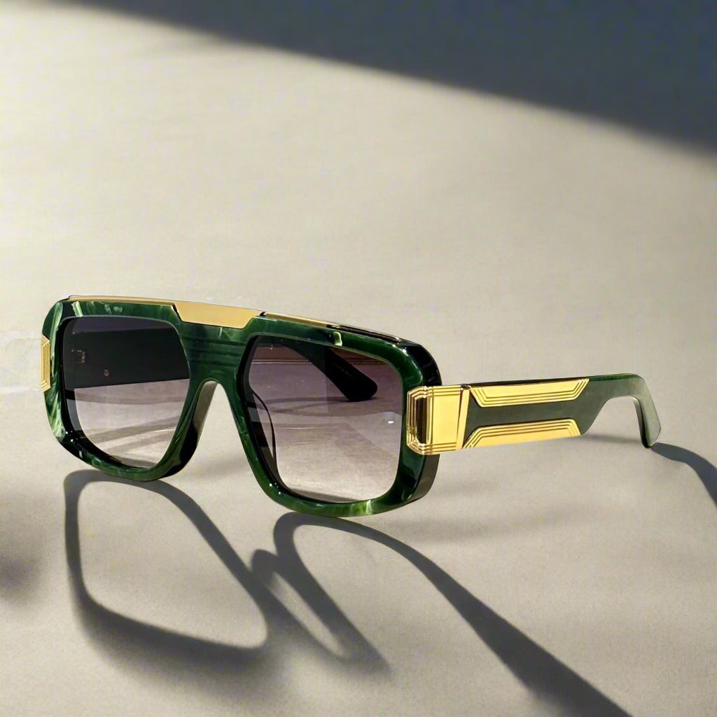 Green and gold sunglasses on a wooden surface with 'ABALMAY' branding.