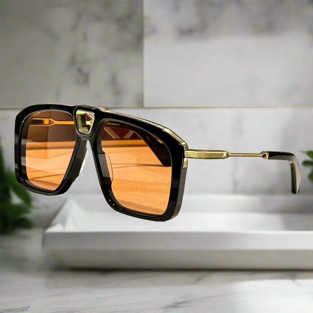 Sunglasses with black frame and orange lenses on a wooden surface