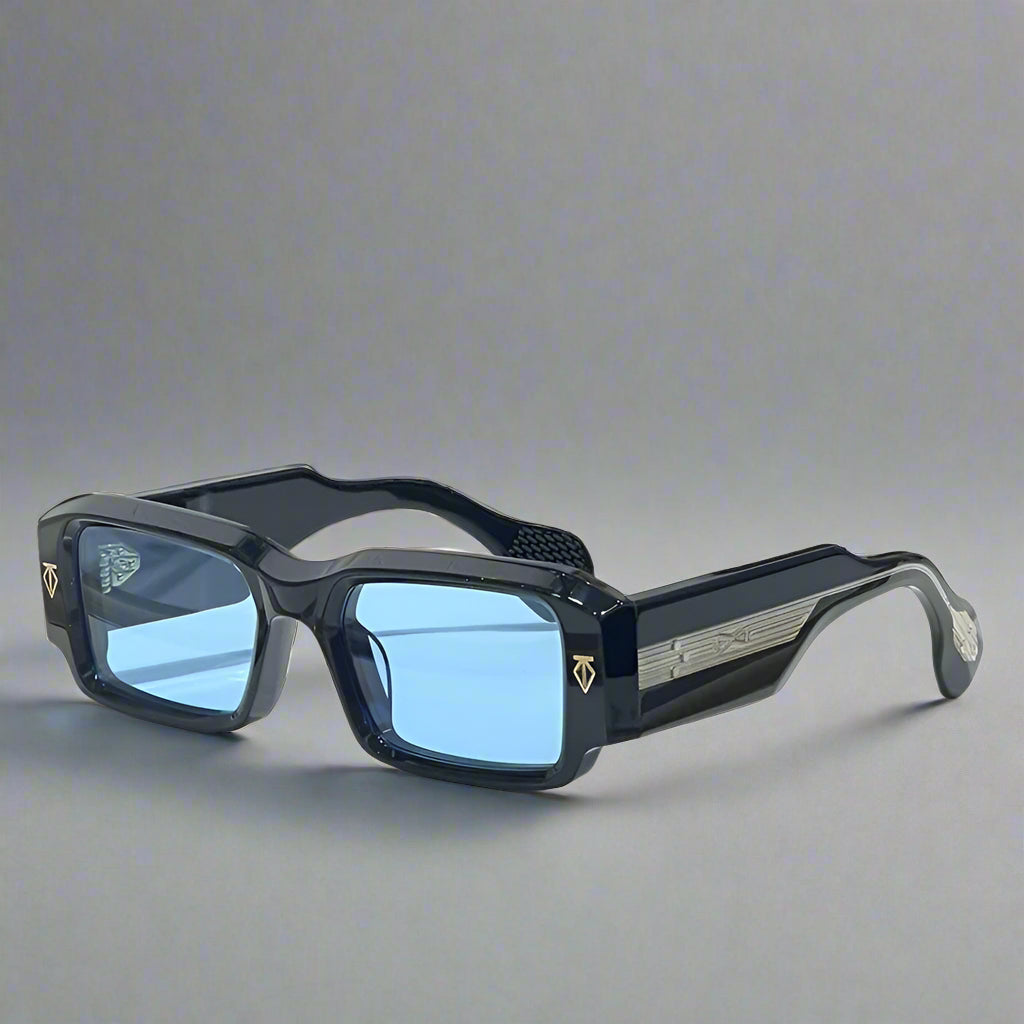Black sunglasses with blue lenses on a white surface with a gray textured background