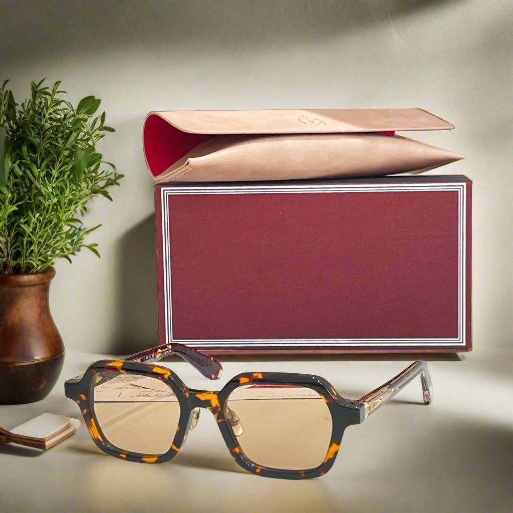 Sunglasses with a branded box on a light surface