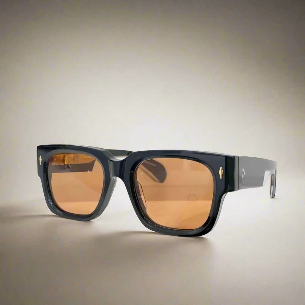 Sunglasses with black frame and brown lenses on a white surface