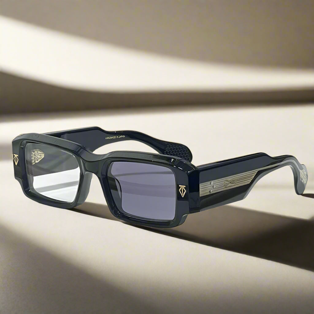 Black sunglasses with gold accents on a wooden surface