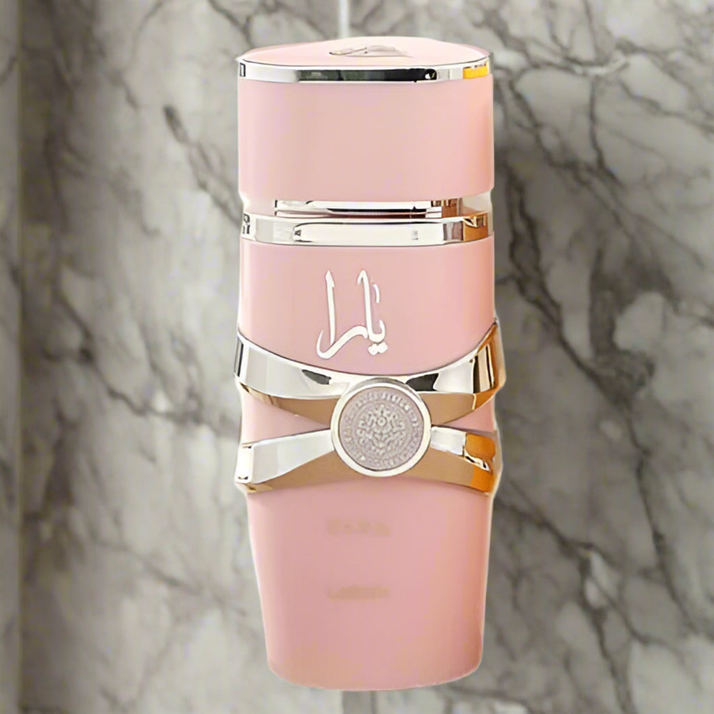 Pink and gold perfume bottle with a white logo on a white background