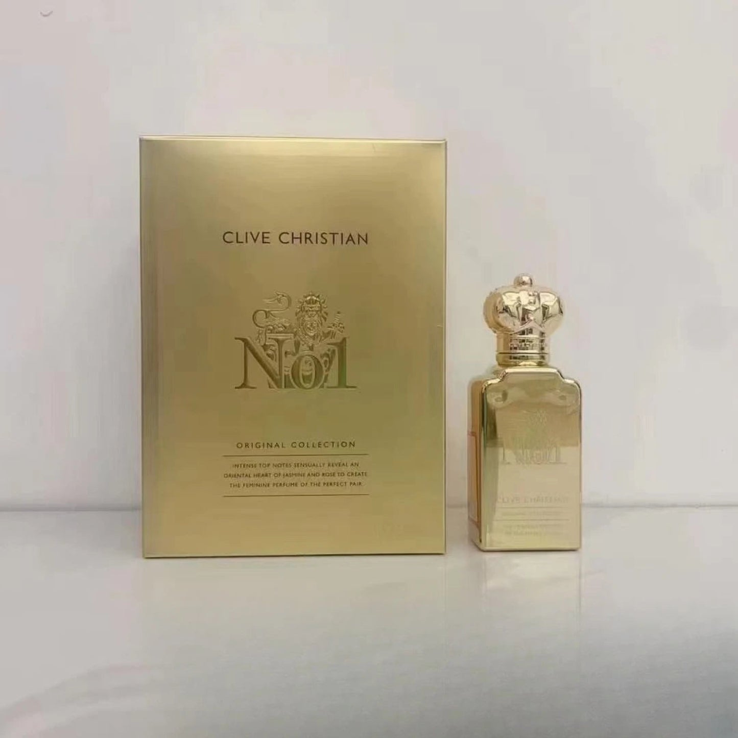 Gold Clive Christian perfume bottle and packaging on a light gray background