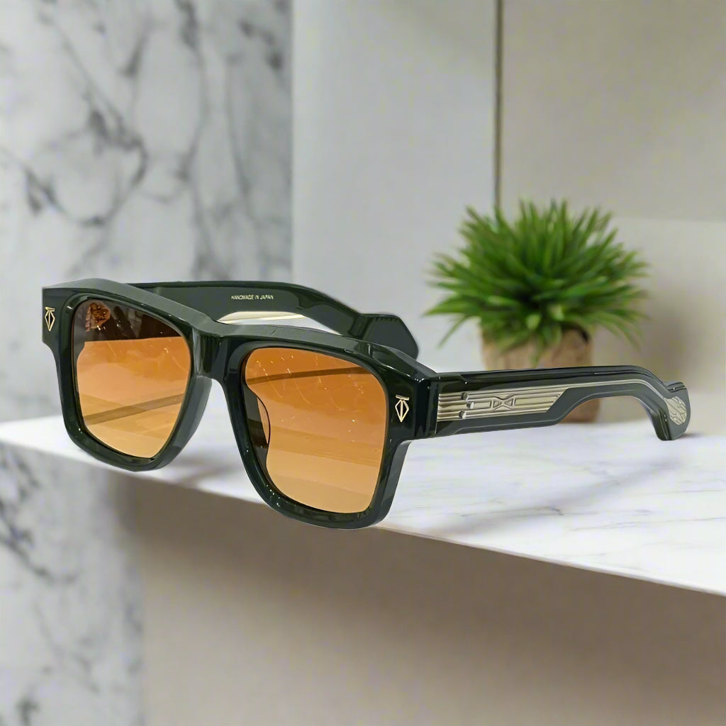 Sunglasses with orange lenses on a white surface with a black case in the background