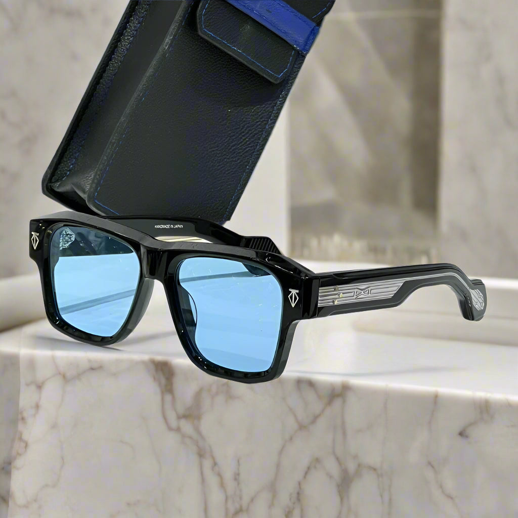 Black sunglasses with blue lenses on a white surface with a black case in the background
