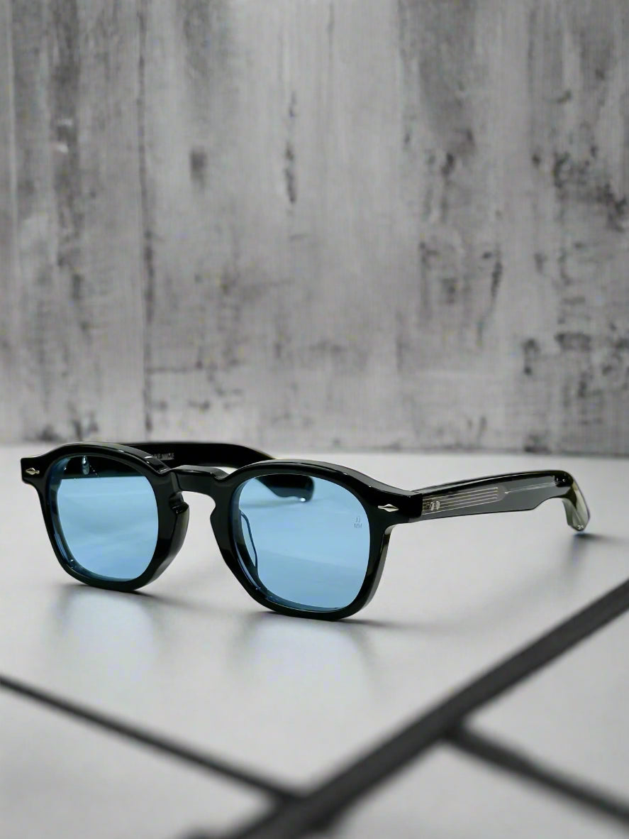 Black sunglasses with blue lenses on a reflective surface, with a green box in the background.