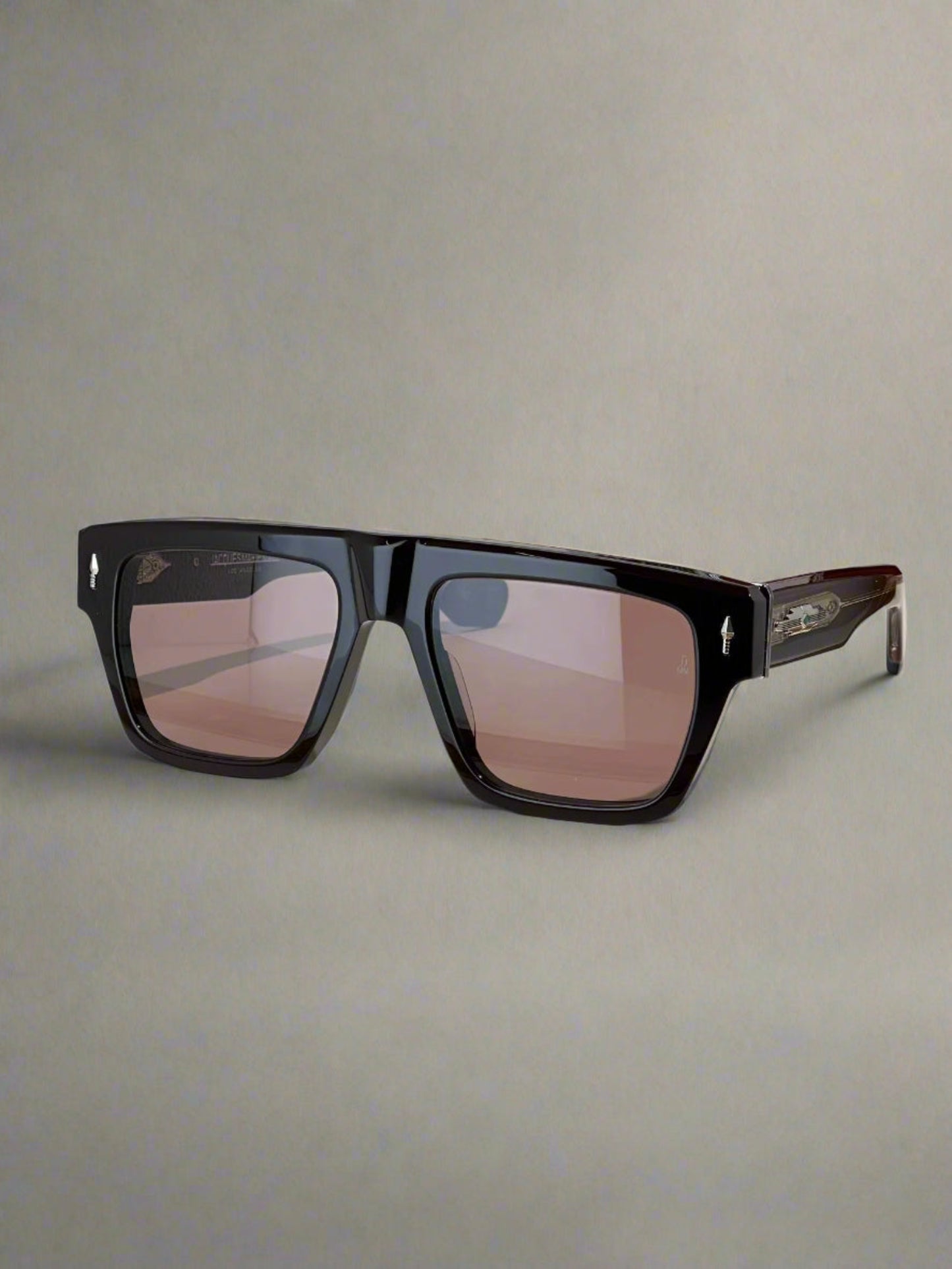 Black sunglasses on a wooden surface with a branded box in the background