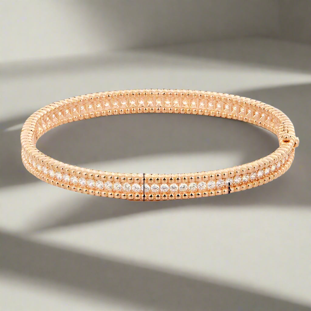 Rose gold bracelet with moissanite stones on a white background