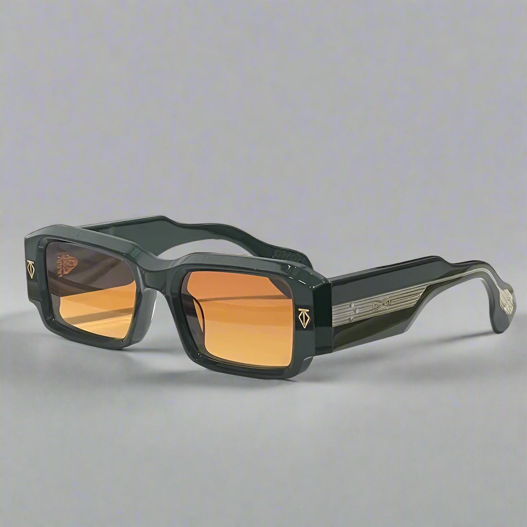 Sunglasses with green frames and orange lenses on a white surface with a textured wall background