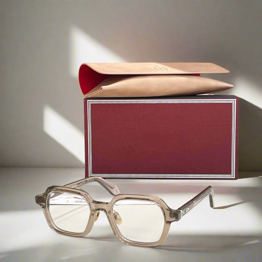 Eyeglasses with a maroon box on a light surface