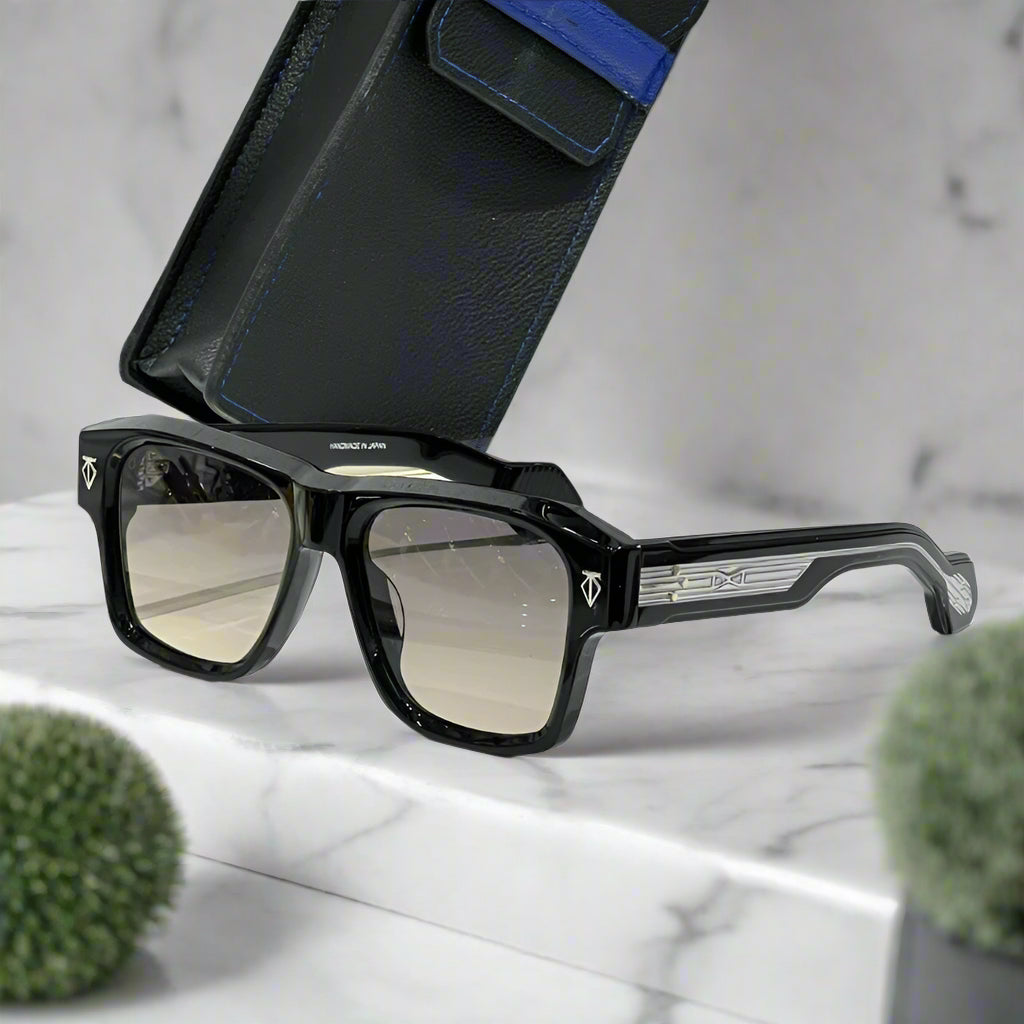 Black sunglasses with a reflective lens on a white surface with a black case.