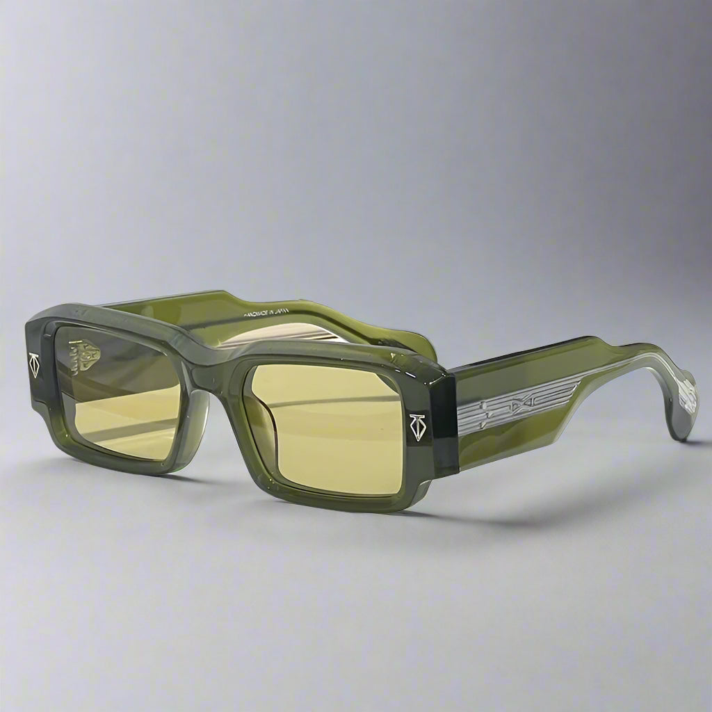 Green sunglasses on a white surface with a textured wall background