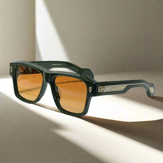 Sunglasses with black frame and orange lenses on a white surface with a gray background