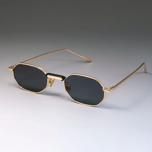 Gold-framed sunglasses with black lenses on a gray background