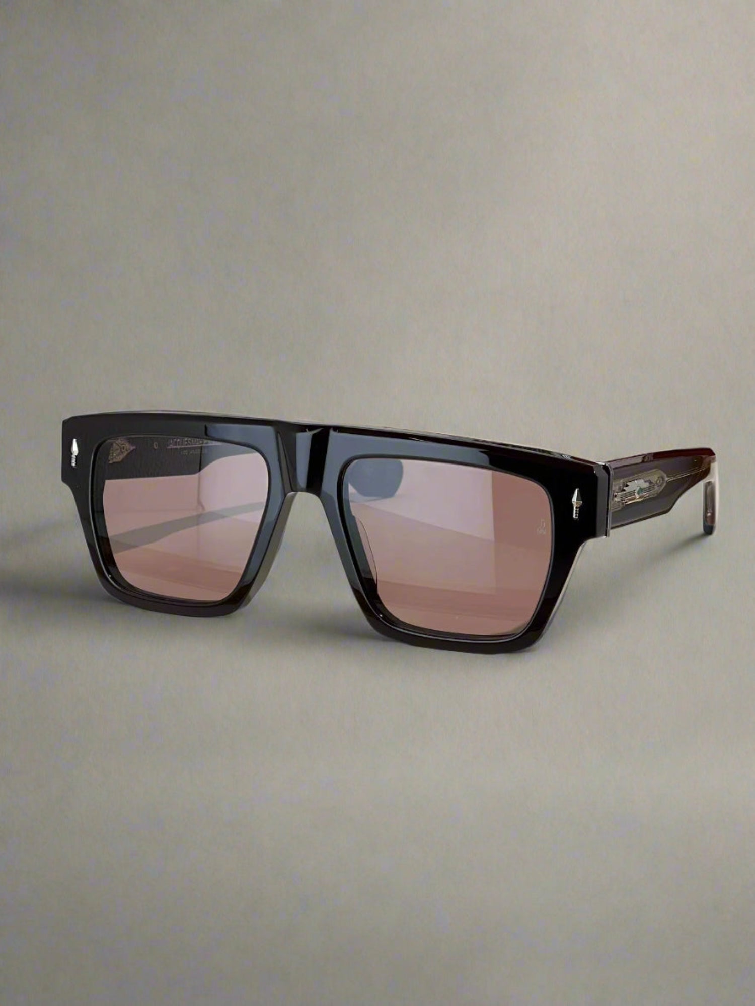 Black sunglasses on a wooden surface with a branded box in the background
