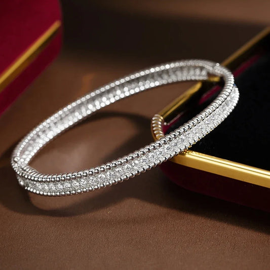 Silver bracelet with diamonds on a brown surface, featuring the ROBUKE brand.